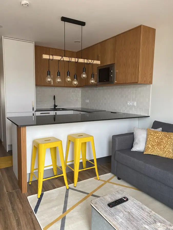 Cozinha aberta com bancos amarelos, fotografia real